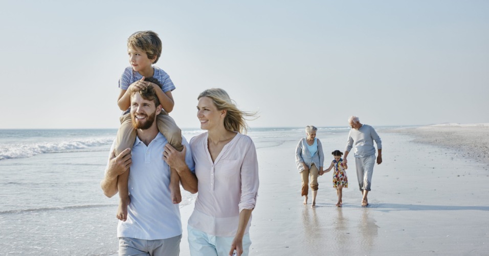 Happy extended family strolling on the beach